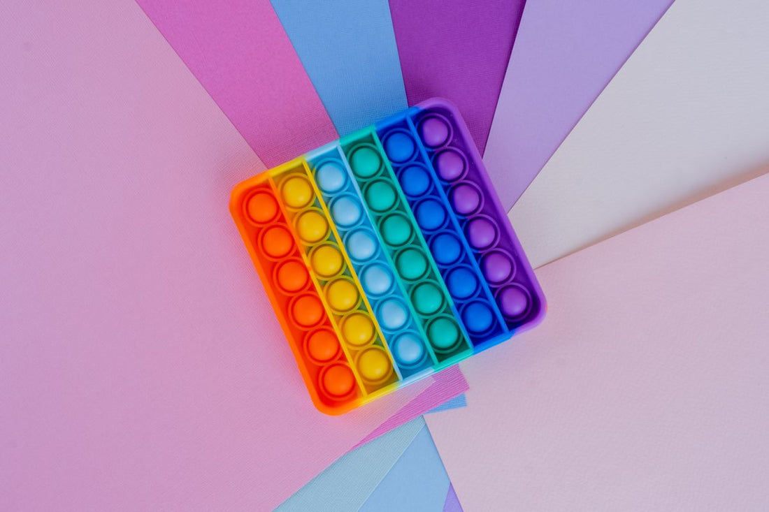 Colorful sensory toy option on a pastel flat lay for choosing cute tactile gifts