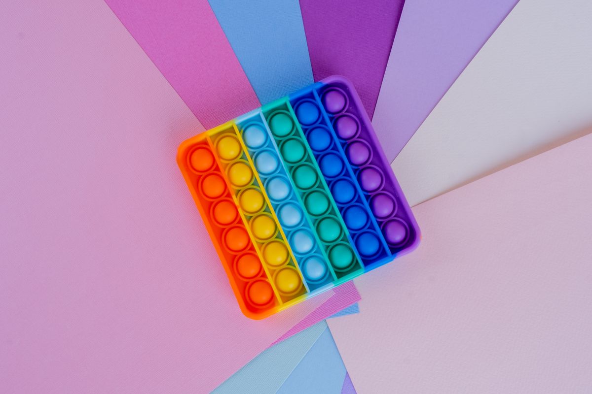 Colorful sensory toy option on a pastel flat lay for choosing cute tactile gifts