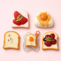 Handmade food-shaped Taba squishy toys arranged on a clean pastel background
